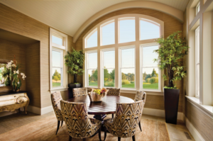 Beautiful custom geometric shaped windows with a curved top in the dining area of a home